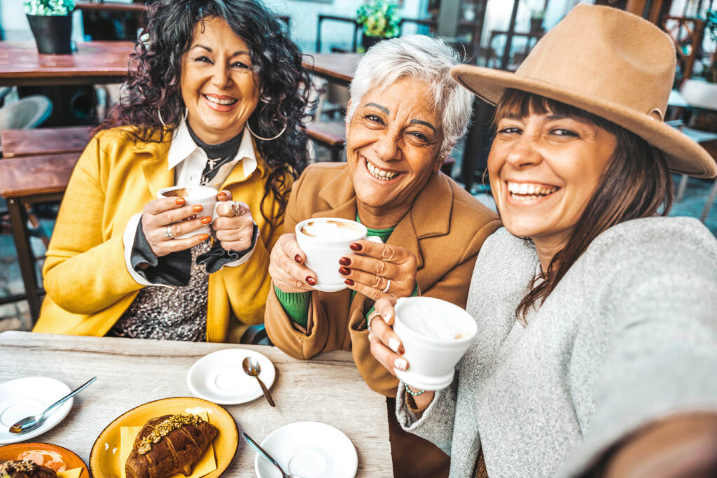 Three senior women enjoying breakfast drinking coffee at bar caf
