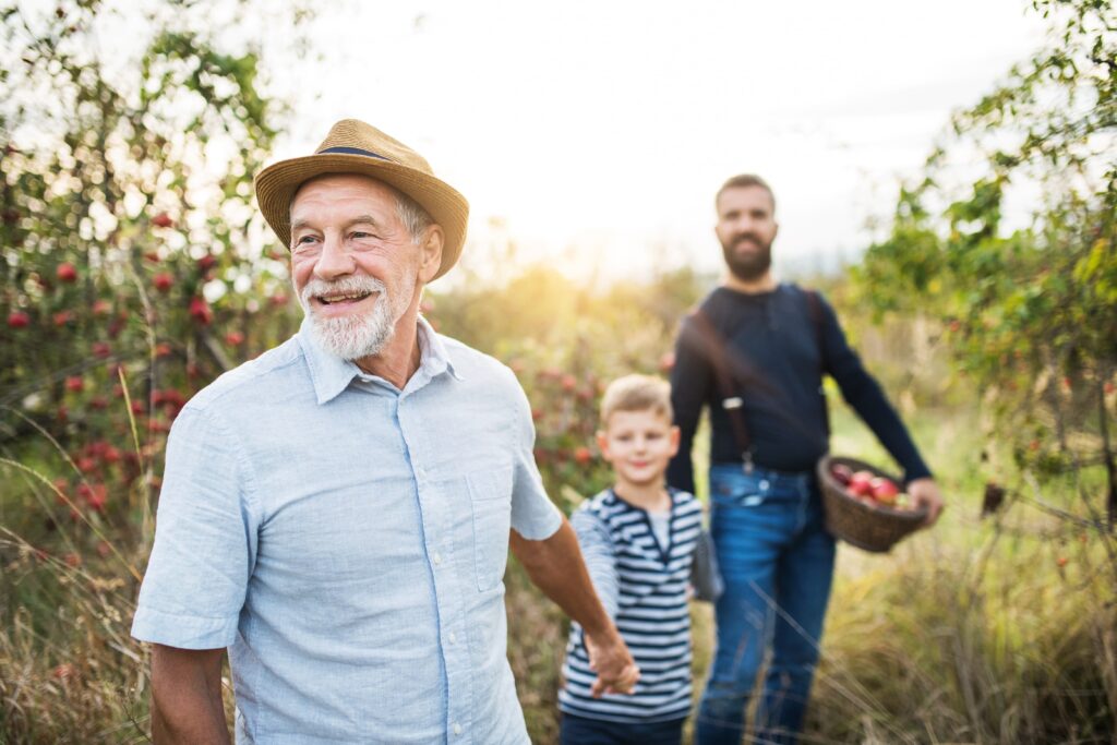 foojan mental health app life area granfather with grandson and son in an orchard holding hands