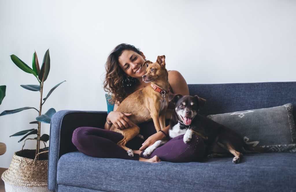 foojan mental health app life area pets woman sitting on couch with two dogs